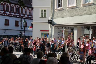Das Bild zeigt einige Zuschauer*innen bzw. Zuhörer*innen am Marktplatz in Nördlingen