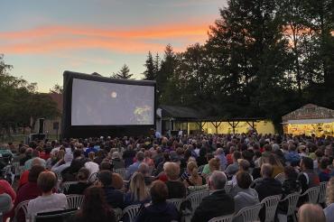 Das Bild zeigt die vielen Zuschauer vor der Leinwand im Musikergarten.