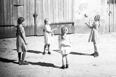 Das schwarz-weiß-Bild zeigt ein paar Mädchen die Ball spielen.