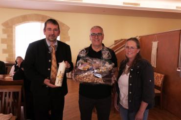 Das Bild zeigt: Diözesanleiter Klaus Probst, ehem. Verbindungsmann Jürgen Tochtermann und neugewählte Verbindungsperson Birgit Haas bei der Überreichung des Geschenkkorbes und der Kerze