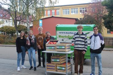 Sowohl die beiden scheidenden Schülersprecherinnen Antonia Engert und Ella Wiedemann (ganz links) als auch die drei neu gewählten Schülersprecher Sebastian Neumayer (3. von links), Georg Held (2. von rechts) sowie Nikolas Braun (ganz rechts) freuten sich über die Lieferung Äpfel von Simon Hurler (3. von rechts), dem Geschäftsinhaber von "Hurler's Obstecke".