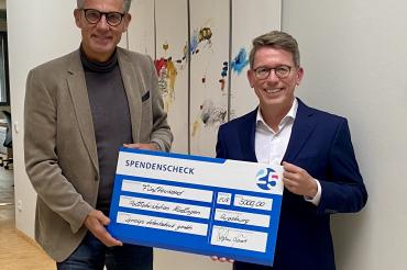 Stephan Krause (rechts) übergibt einen symbolischen Scheck in Höhe von 5.000 Euro an einen Mitarbeiter des Stiftungskrankenhauses.