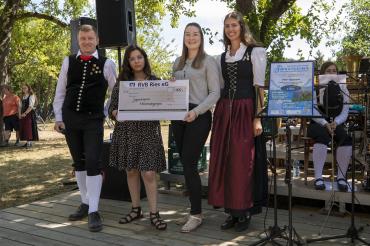 Das Bild zeigt Mitarbeiter*innen der Raiffeisen Volksbank Ries und Musiker*innen der Jugendkapelle Mönchsdeggingen bei der Spendenübergabe. 