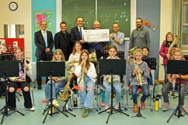 Unser Bild zeigt mit 14 Schülerinnen der Bläserklasse von links Schulwerk-Direktor Peter Kosak, OB Jürgen Sorré, Sparkassendirektor Johann Natzer, Realschuldirektor Peter Müller, den Leiter der Bläserklasse Tobias Freißler und den klasse.im.puls-Projektmanager der Friedrich-Alexander-Universität Erlangen-Nürnberg, Christoph Utz.