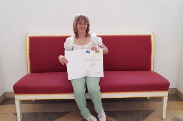 Das Bild zeigt Sarah Schweidler mit ihrer Wettbewerbsurkunde.