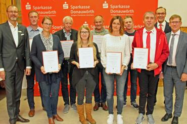 Das Bild zeigt von links Sparkassendirektor Michael Scholz, Dietmar Wegert (Gemeinde Otting), Alexandra Kammer (Rektorin Grundschule Tapfheim), Johann Mair (AWO-Vorsitzender Mertingen), Franziska Wiedemann (Dr.-Hermann-Fendt Kindergarten Asbach-Bäu- menheim), Markus Harsch (Zweiter Bürgermeister Kaisheim), Steffi Dußmann (SV Marxheim), Fabian Seefried (Jugend Belzheim), Roman Leister (Spielvereinigung Herblingen-Hochaltin- gen), Sparkassendirektor Johann Natzer sowie den Vorsitzenden des Stiftungsvorstandes