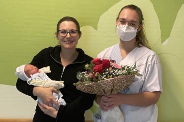 Mutter Julia Scherer trägt ihr Jubiläums-Baby Lorenz voller Stolz. Krankenschwester Katharina Hötzl gratulierte mit Blumen.