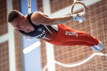 Pavel Karnejenko bei einem hochwertigen Kraftelement an den Ringen.