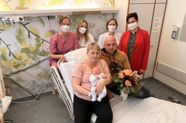 Swetlana und Andreas Anton mit ihrem Sohn Michael. Hebamme Heike Eber, Stationsleiterin Andrea Lechner, Oberärztin Dr. Anne-Kathrin Geisler und Pflegedienstleiterin Michaela Rechner (von links) freuen sich mit den Eltern und überreichten einen Blumenstrauß.