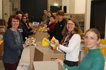 das Bild zeigt Menschen die einpacken