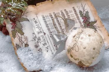 Das Bild zeigt ein Notenblatt mit weihnachtlicher Dekoration.