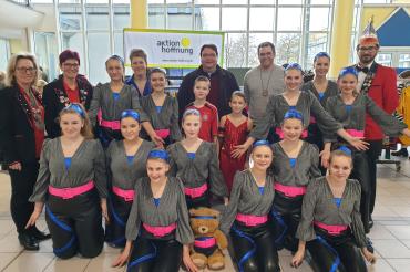 Der Marktorganisator Simon Briglmeier (hintere Reihe 3. von rechts) freute sich, dass neben vielen Kundinnen und Kunden auch Pfarrer Jörg Biercher (hintere Reihe4. von rechts) und die Kindergarde mit ihren Verantwortlichen beim Faschingsmarkt zu Gast waren. 