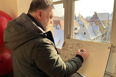 Künstler Alexander Wachtel beim Zeichnen in der Stadtbibliothek.