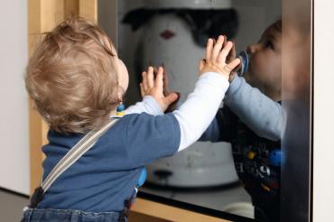 DAs Bild zeigt ein Kleinkind vor dem Backofen.