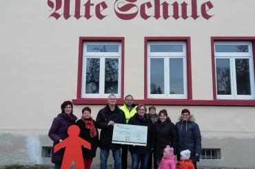 Markus Mayinger (3. von links), Ortssprecher in Rehau, übergibt gemeinsam mit Bürgern aus Rehau, die sich an der „Weihnachtsfenster-Aktion" beteiligt haben, den symbolischen Spendenscheck an Susanne Eser, Nachsorgeschwester beim Bunten Kreis. 