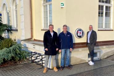 Benedikt Bigler (Allianz), Tobias Streitwieser (BRK Wemding) und Bernd Huber (Allianz) vor dem neuen Defibrillator in Wemding.