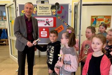 Herr Weiland überreicht jedem Kind eine Flöte.