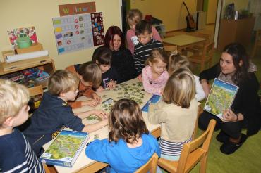 Sonja Schimmel und Jennifer Werner vom Regionalmanagement übergeben das Landkreis Puzzle Donau-Ries an die Kinder des Heilig-Kreuz Kindergartens in Donauwörth.