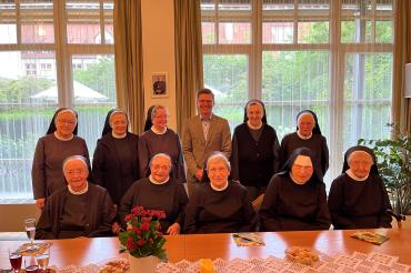 Oberbürgermeister David Wittner gratuliert Sr. Adelhilde (beide Mitte hinten) zum runden Geburtstag. 