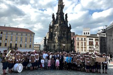 Die offizielle Delegation, angeführt von Oberbürgermeister David Wittner mit der Knabenkapelle Nördlingen vor der Dreifaltigkeitssäule (UNESCO-Weltkulturerbe) auf dem Marktplatz der Partnerstadt Olomouc.