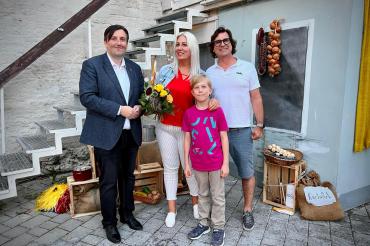 Der erste Vorsitzende Axel Schönmüller (links) hat mit Katrin Schultes und ihrer Familie die 10.000 Besucherin auf der Freilichtbühne begrüßt.