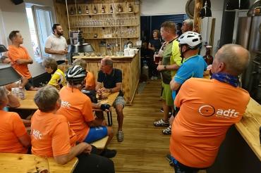 Das Donauwörther Brauhaus erstrahlte in orange. ADFC-Vorsitzender Steffen Reddel (links, stehend) und der Radverkehrsbeauftragte des Landkreises Donau-Ries, Alexander Wolfinger (3.v.r.) bedanken sich bei Bernhard Strauch vom Donauwörther Brauhaus (2.v.l., stehend) für die freundliche Aufnahme, das Freigetränk und die interessanten Informationen.
