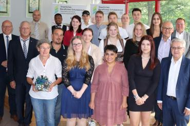 Die „frischgebackenen“ Bäckergesell*innen sowie die Fachverkäuferinnen im Lebensmittelhandwerk, Schwerpunkt Bäckerei freuen sich zusammen mit Kreishandwerksmeister Werner Luther (rechts) und Ehrengästen über ihren erfolgreichen Berufsabschluss.