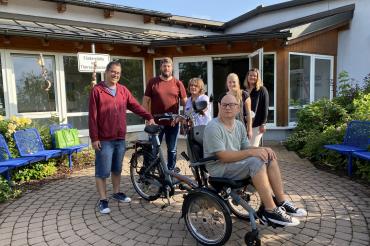 Das Bild zeigt das Team der Förderstätte mit einer der der neuen Rikschas.