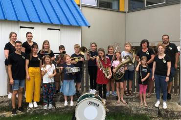 Das Bild zeigt die teilnehmenden Kinder des Ferienprogrammes zusammen mit den Jugendleitern und weiteren Musikerinnen und Musikern der Stadtkapelle Harburg.