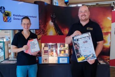 Carmen Uhl und Markus Meyr bei der Vorstellung des neuen Rauchhauses anlässlich der Donauries-Ausstellung und dem offiziellen Start des Bastelwettbewerbes für die Feuerwehr-Kinder.