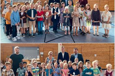 Unser Bild zeigt die Klasse 1a (oben) und die Klasse 1b (unten) mit der Direktorin Stefanie Fuß, den jeweiligen Klassenlehrer*innen, Susanne Ablaßmeier-Reiner (1a) und Robert Schmidt (1b), Bürgermeister Christoph Schmidt und den stellvertretenden Leiter der Geschäftsstelle Harburg, Sebastian Bitomsky.