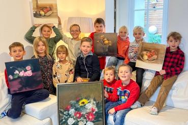 Das Bild zeigt die Kinder der Lionsclub-Mitglieder mit den zu versteigernden Werken Ruißings.