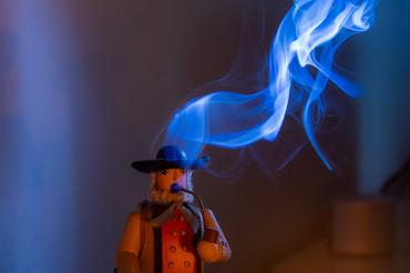 Das Bild zeigt eine räuchernde Holzfigur.