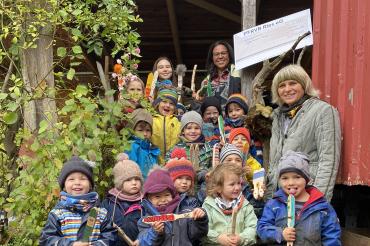 Die Kinder und Erzieherin Christiane Koffler (Mitte rechts) freuten sich über die Spende, die Marietta Schmidt (oben rechts), Organisatorin des Bürstenflohmarkts, vor Ort im Waldkindergarten übergab.