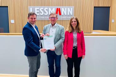 Landrat Stefan Rößle (Mitte) überreicht Daniel Lehn (links), Beauftragter für Umweltmanagement bei Lessmann, und Cornelia Kitzsteiner (rechts), Vertriebsleitung, die Urkunde für die Aufnahme in den Umweltpakt.