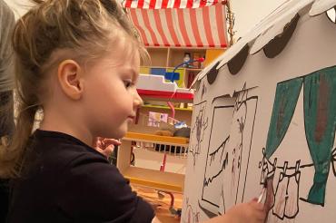 Mit großer Konzentration bemalt Lea ihr Spielhaus aus Wellpappe, um am Gestaltungswettbewerb teilzunehmen. 