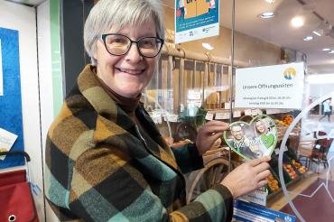 Geschäftsführerin Christiane Kickum mit dem Aufkleber „Dorfladen mit Herz“.