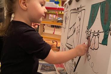 Mit großer Konzentration bemalt Lea ihr Spielhaus aus Wellpappe, um am Gestaltungswettbewerb teilzunehmen. 