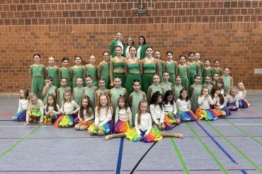 Das Bild zeigt die Mädchen der „Just Dance Minis“ in der vordersten Reihe, kniend in der mittleren Reihe die „Just Dance Kids“ und stehend in der hinteren Reihe die „Just Dance Teens“. Dahinter stehen die drei Trainerinnen, Meike Jörg, Lea Richter und Alina Schmidt.