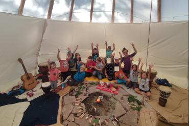 Auf dem Bild sind Kinder in einem Tipi zu sehen.
