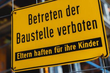 Baustellenschild mit der Aufschrift "Betreten der Baustelle verboten, Eltern haften für ihre Kinder"