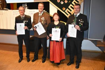 Vier Menschen, die Jeweils eine Urkunde halten.