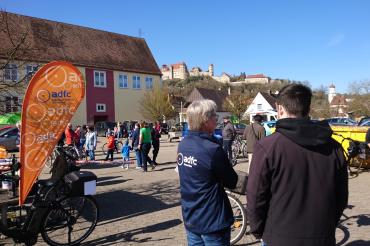 Zwei Menschen im Vordergrund, Menschen laufen im Hintergrund und das Schloss Harburg ist zu sehen