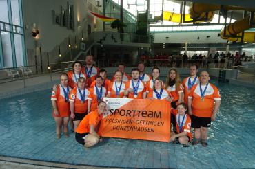 Das Schwimmteam in oranger Kleidung
