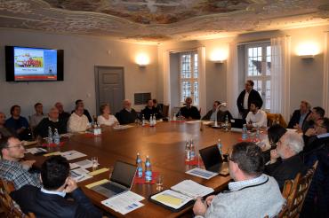 Die Mitglieder des Entscheidungsgremiums sitzen um einen Tisch