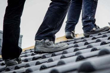 Oben auf dem Dach wartet jede Menge Arbeit – und für die gibt es ein „Mindest-Lohn- Preisschild“: 15,60 Euro pro Stunde – das ist das Minimum, was Gesellen auf dem Dach verdienen müssen.