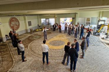 Die Teilnehmer an der Projektwoche „Begabtenförderung Straßenbauer“ blicken stolz zusammen mit den Ausbildern und Vertretern der Politik auf ihre Arbeit in der der Straßenbauhalle der Bauinnung Nordschwaben in Nördlingen