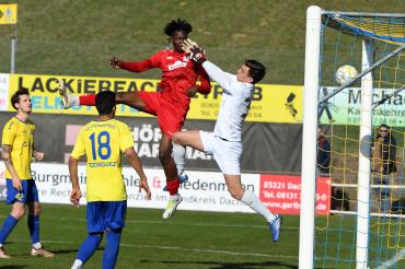 Ein Fußballspieler den Springt und ein Tor macht 