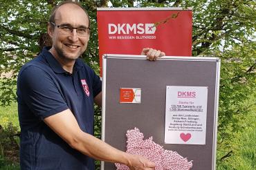 Daniel Lichtenstein während er eine Stecknadel in eine Karte steckt