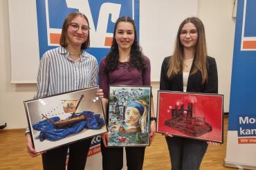 Drei Personen die Jeweils ein Bild in der Hand halten